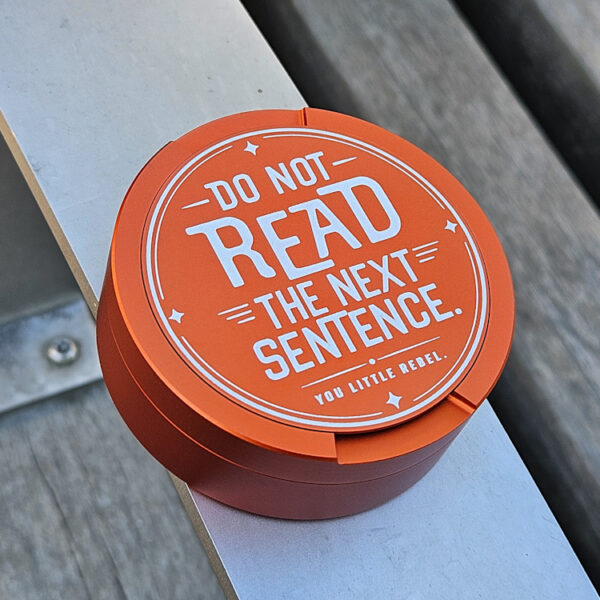 Orange snusdosa med texten Do Not Read The Next Sentence
