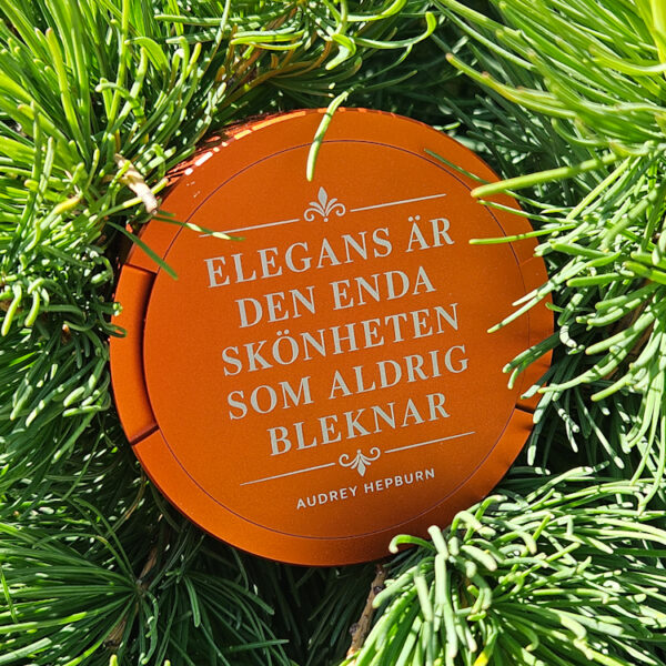 Guldfärgad snusdosa med citatet Elegans är den enda skönheten som aldrig bleknar