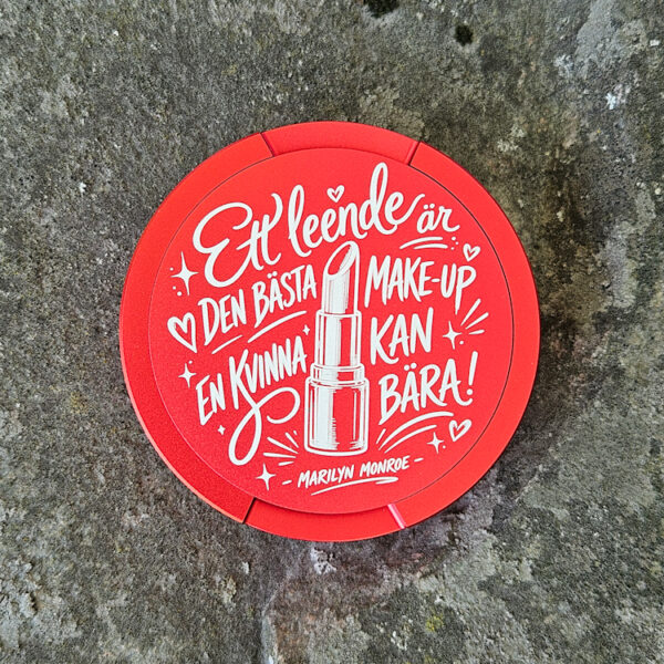 Röd snusdosa med citatet Ett leende är den bästa make-up en kvinna kan bära